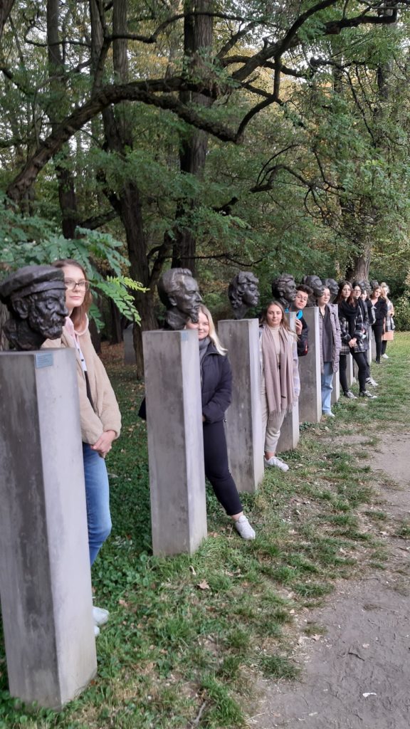 Fotografia pokazuje uczniów klasy 4TMA na tle rzeźb Xawerego Dunikowskiego „ Panteon kultury polskiej”