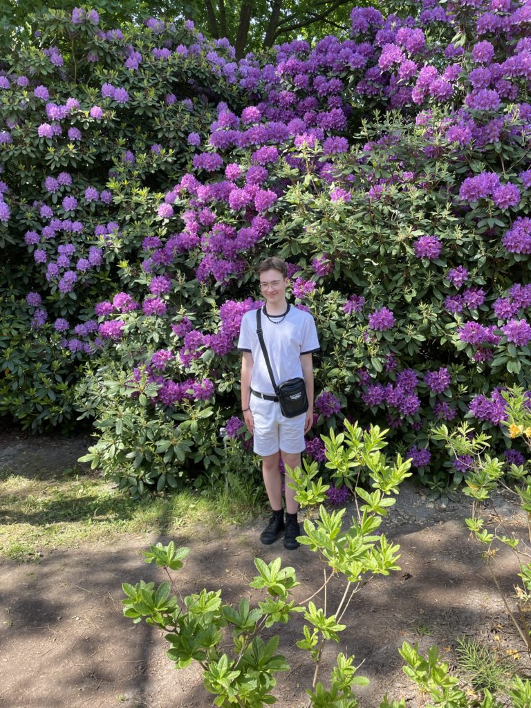 uczeń na tle rododendronu 